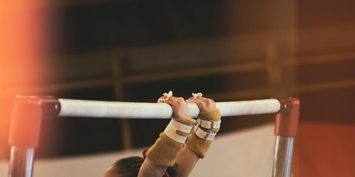Uneven bars gymnastic background detail of female athlete hands during sport performance