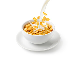 Pouring milk into the bowl of corn flakes isolated on white background.