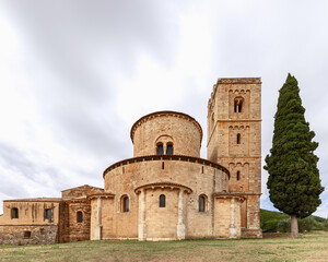 Fototapeta premium The&nbsp;ambulatory with radial chapels, belltower, and cypress in&nbsp;Abbey Sant Antimo. Val d'Orcia, Tuscany, Italy