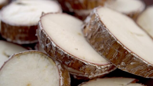 Sliced yucca root. Raw manioc slices. Macro. Rotation. Dried cassava plant