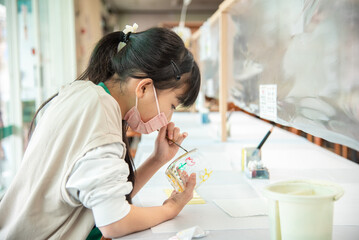 ガラス体験工房で絵付け体験をするアジア人の女の子