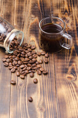 Cup of coffee and beans are scattered from a glass jar.