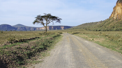 Beautiful african landscape. Dirt road in the middle of Kenyan landscapes. Road in the mountains under the blue sky in Africa.