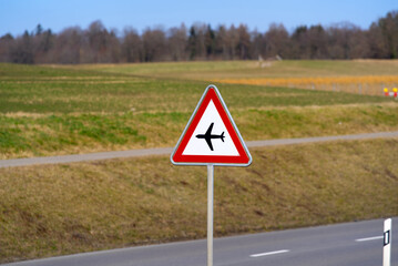 Traffic sign beware of air traffic near tee airport on a sunny winter day. Photo taken February...