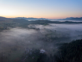 Morning mist in Ukrainian Carpathian mountains. Aerial drone view.