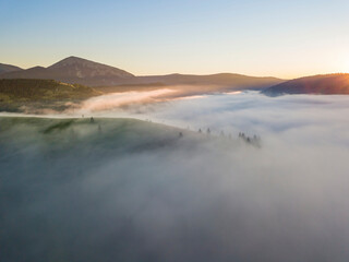 Sunrise over the fog in the Ukrainian Carpathians. Aerial drone view.