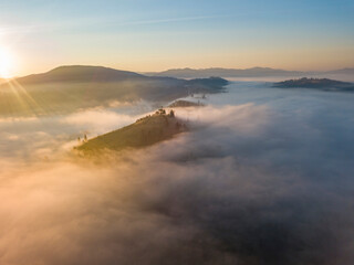 Fototapeta premium Sunrise over the fog in the Ukrainian Carpathians. Aerial drone view.