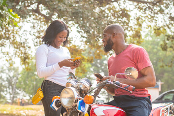 african man and woman sharing content from their phones
