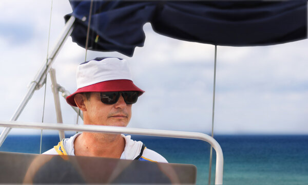 A 45-46-year-old man on a boat trip in a panama hat and sunglasses.