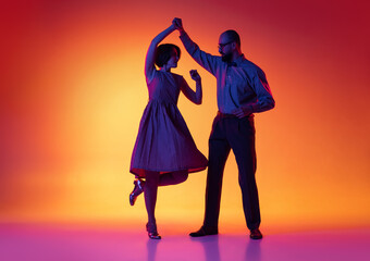 Portrait of excited man and woman, couple of dancers in vintage retro style outfits dancing lindy...