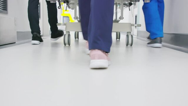 Doctors team pushing bed in hospital corridor