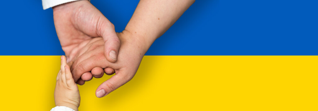 Flagge der Ukraine mit den H&auml;nden einer Familie mit einem Kind