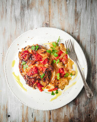 Pork chops with onion, bell peppers and cheese