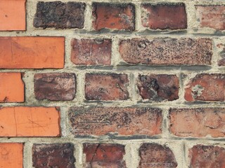 Détail macro d'un mur en brique avec variation des couleurs en fonction des différences de...