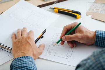 Box designer making a sketch on paper. Hands only,no face