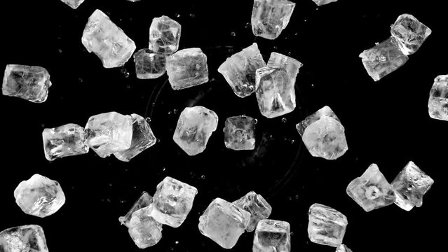 Super slow motion of rotating ice cubes on black background, top view shot. Filmed on high speed cinema camera, 1000 fps. Speed ramp effect.
