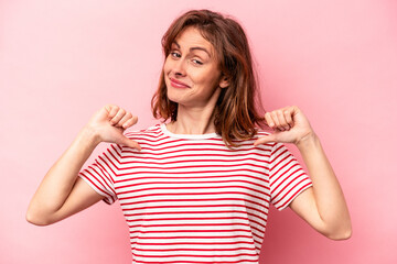 Young caucasian woman isolated on pink background feels proud and self confident, example to follow.