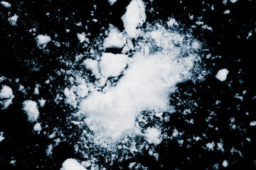 Smashed snow powder on black background.