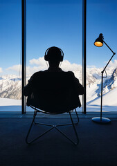 Man listen music by headphones in hotel room with Mountain View