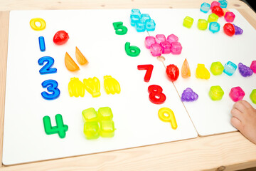 Numbers and toys. Artificial fruits and digits. Idea for children learning to count. Montessori...
