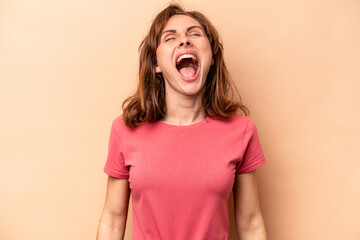 Young caucasian woman isolated on beige background relaxed and happy laughing, neck stretched showing teeth.