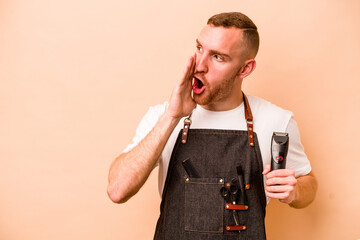 Young hairdresser caucasian man isolated on beige background is saying a secret hot braking news...