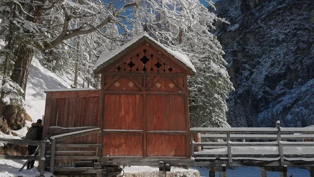 Wooden mountain hut on the frozen surface of Lake Braies, in the snowy Dolomites, Italian Alps