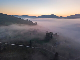 Fototapeta premium Sunrise over the fog in the Ukrainian Carpathians. Aerial drone view.