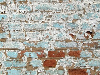 Restes de peintures bleue et blanche écaillées sur un vieux mur de briques