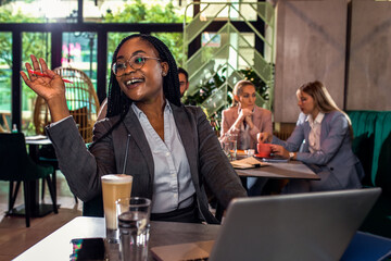 Young African American businesswoman working at cafe.
