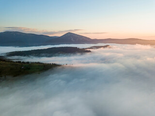 Sunrise over the fog in the Ukrainian Carpathians. Aerial drone view.