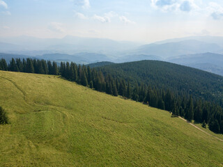 Green mountains of Ukrainian Carpathians in summer. Sunny day, rare clouds. Aerial drone view.