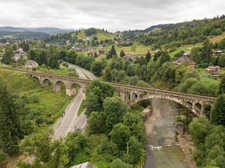 Fototapeta premium Old railway bridge in the mountains. Ukrainian Carpathians. Aerial drone view.