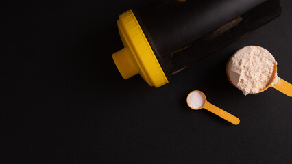 a portion of gainer or whey protein shake in a scoop on a black background top view. Whey protein and carbohydrates for weight gain
