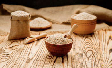 Barley groats in bowls and bags on a wooden background. High quality photo