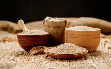 Barley groats in bowls and bags on a wooden background. High quality photo