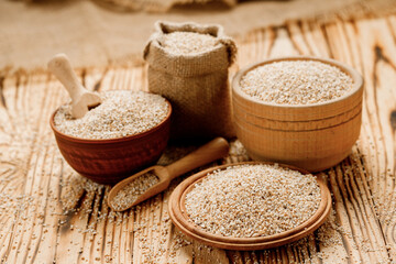 Barley groats in bowls and bags on a wooden background. High quality photo
