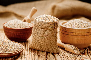 Barley groats in bowls and bags on a wooden background. High quality photo