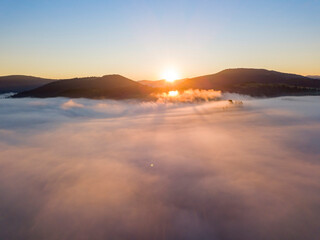 Obraz premium Sunrise over the fog in the Ukrainian Carpathians. Aerial drone view.
