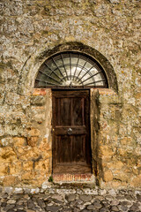 Old wooden locked door of a stone house in Italy