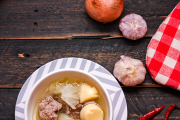 Boiled tofu and minced pork served in white cups served on a black wooden table.