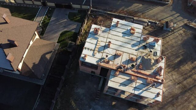 professional construction worker laying bricks and building house in industrial site. top aerial view.