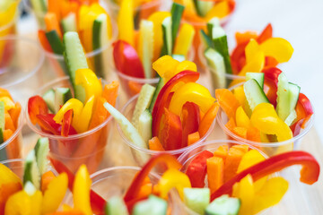 Beautifully decorated catering banquet table with variety of colorful vegetables and different vegan vegetarian snacks appetizers setting on corporate birthday party event or wedding celebration