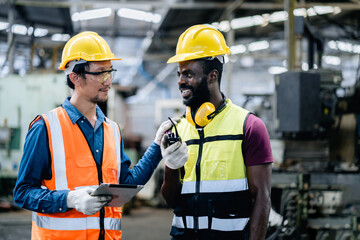 Industrial workers or Technicians using a digital tablet and discussing workshops mechanical...