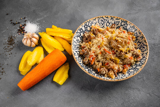 Pilaf - Rice with Meat and Vegetables. Garnished with Onions and Tomatoes Salad