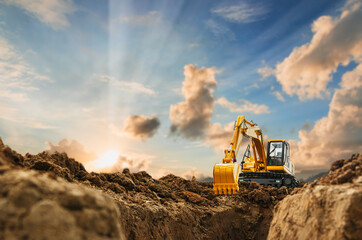 Excavator with Bucket lift up are digging  soil in the construction site on the blue sky and sunset...
