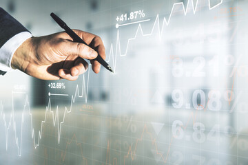 Double exposure of man hand with pen working with abstract creative financial chart hologram on blurred office background, research and strategy concept