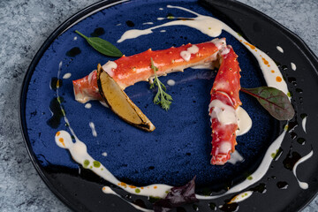 cooked phalanx of crab in a blue plate on an autumn background with hay and a glass of white wine