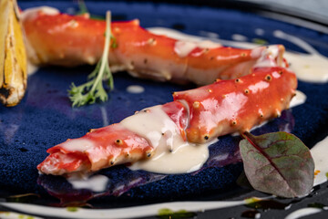 cooked phalanx of crab in a blue plate on an autumn background with hay and a glass of white wine