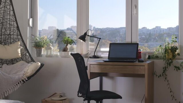 Home office workplace with laptop on wood table with city background